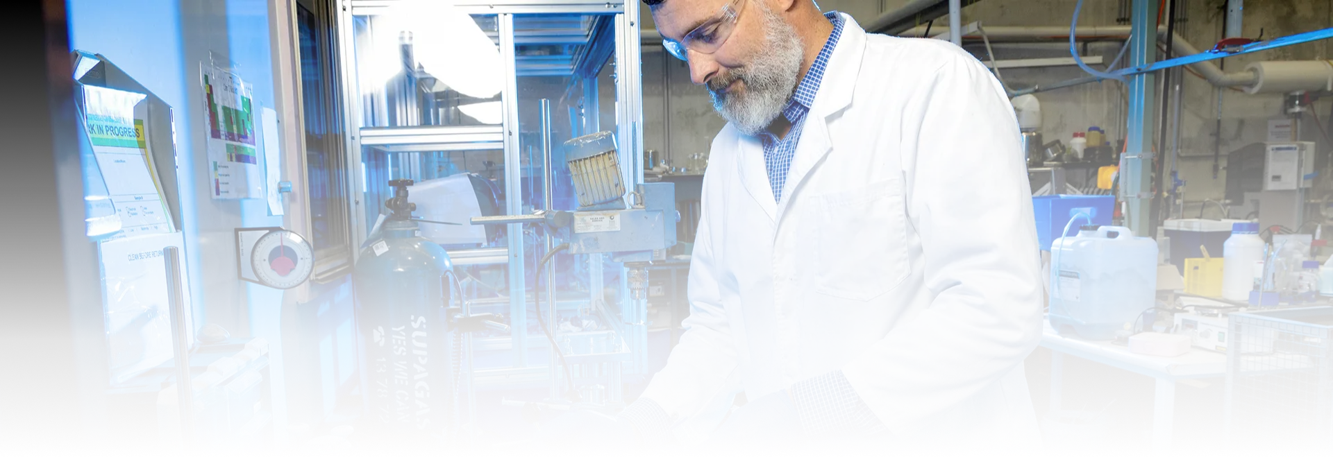 A Lava Blue researcher in a lab coat working at a bench in the PRiSM laboratory